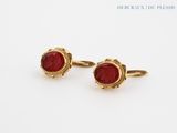 pair of gold and red glass cufflinks on a white background