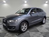 une Audi QX grise garée sur un sol en carrelage à damier