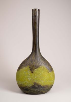 a yellow and black vase sitting on a white surface