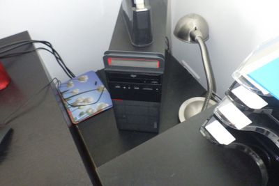 un ordinateur de bureau posé sur un bureau, à côté d'une lampe