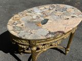 a table with a marble top sitting on the pavement