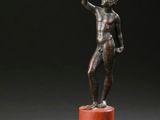 statue en bronze représentant un homme debout sur un socle, le bras levé