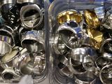 two plastic containers with silver and gold items in them