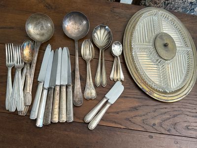 a lot of silverware on a wooden table