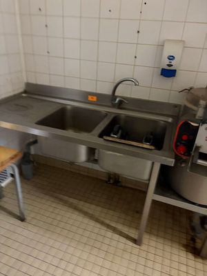 une cuisine équipée d'un évier, d'une cuisinière et d'une planche à découper