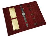 a red cloth with a watch and other items on it