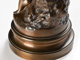 bronze statue of a woman with a dog on a rock