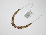 gros plan d'un collier sur une surface blanche avec une étiquette de prix