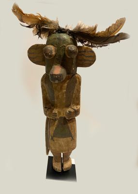 a wooden sculpture of a man with feathers on his head