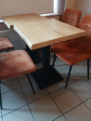 une table avec quatre chaises et un banc dans une pièce