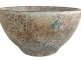 a brown and green bowl sitting on a white surface