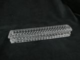 a clear glass vase with a long handle on a black background