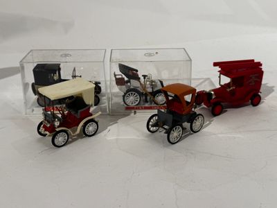 three toy cars in a clear box on a white surface
