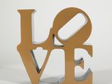 the word love is cut out of wood and placed on a white surface