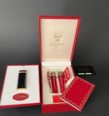 an open red box with a lipstick and a lipstick brush in it