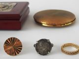 five different rings and a ring box on a table
