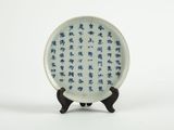 une assiette décorée de motifs bleus et blancs, posée sur un socle
