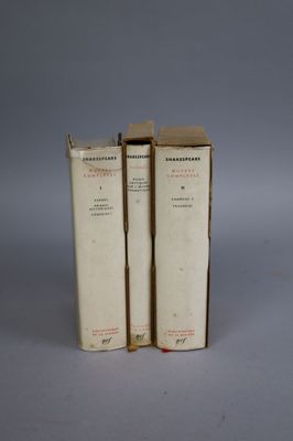 three books are stacked on top of each other on a gray surface