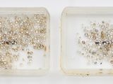deux boîtes transparentes remplies d'une multitude de petites perles, posées sur une surface blanche