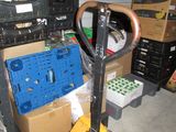 a fork and a cart in a garage with boxes on the floor