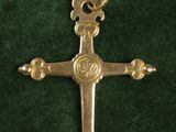 an image of a gold cross on a green velvet surface