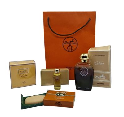 an assortment of perfume bottles and boxes on a white surface
