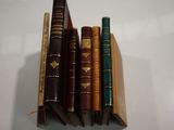 five books stacked on top of each other on a table