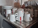 a man that is putting cups in a coffee machine