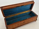 an old wooden box with a blue lining inside on a white surface