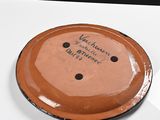 a brown plate with writing on it sitting on a table