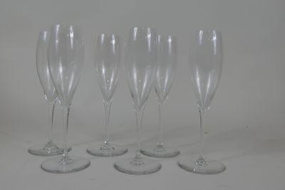 four empty wine glasses are lined up on a white surface