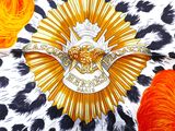 an image of a pin with a gold eagle on a leopard print background