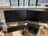 un bureau sur lequel sont posés deux écrans d'ordinateur et un clavier