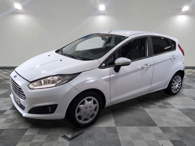 la ford fiesta blanche est garée dans une pièce au sol à carreaux