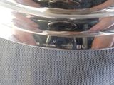 a reflection of a person holding a camera in a glass bowl