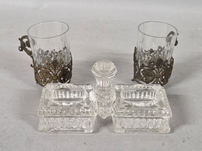 two glasses and a candle holder sitting on a table