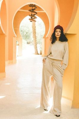 a woman that is standing in a hallway wearing a hat