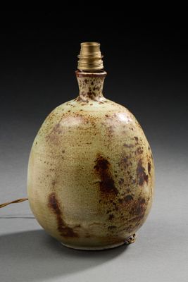 un vase marron et blanc sur lequel est posée une lampe