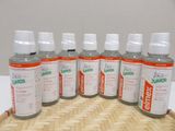 six bottles of liquid sitting on top of a wooden tray