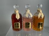 three bottles of perfume sitting on top of a glass shelf