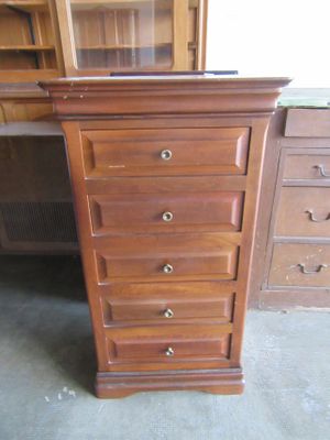 a tall wooden dresser with drawers in a room