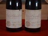 two bottles of wine sitting on a table next to each other