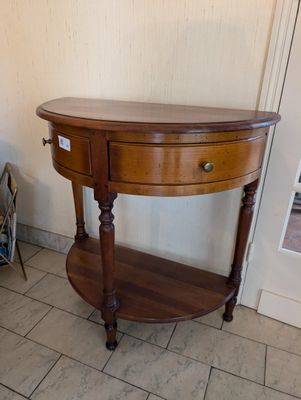 a wooden table with a drawer on it in a room