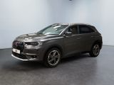Le SUV gris est garé dans une pièce au sol noir.