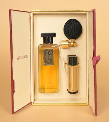 an open box with a bottle of perfume and a microphone in it