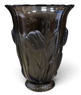 un vase noir posé sur une surface blanche