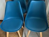 quatre chaises bleues placées les unes à côté des autres dans une pièce