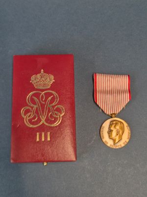 une image représentant un livre rouge orné d'une médaille