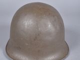 un vieux casque est posé sur une surface blanche