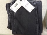 a pair of black jeans with a price tag on them